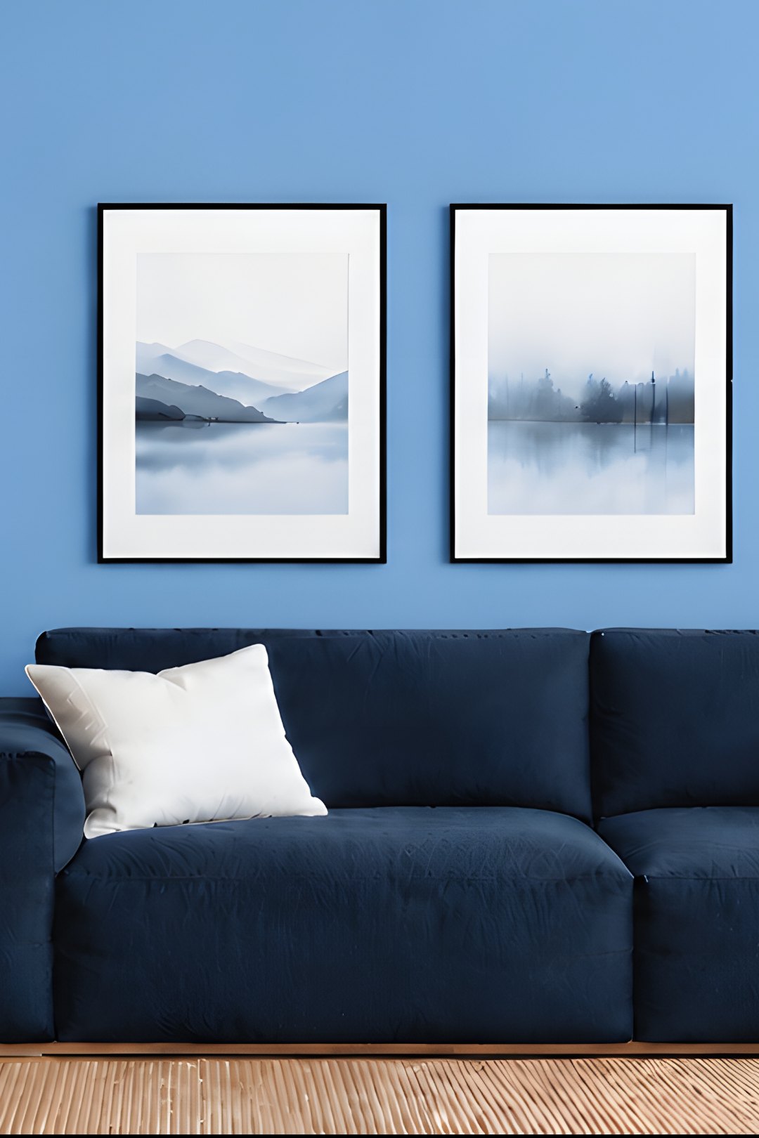 Three framed prints in a row above a navy sofa on a blue wall